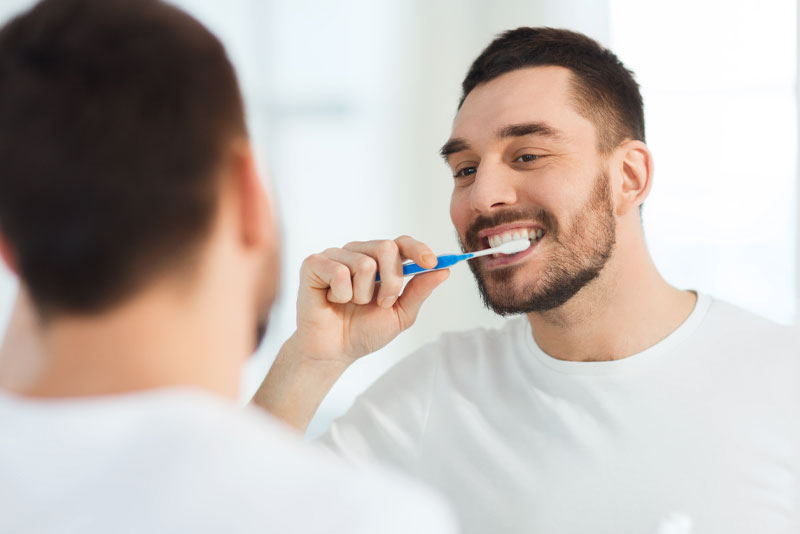 dental veneers patient brushing his teeth